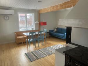 a living room with a table and a blue couch at Lissmogården in Leksand