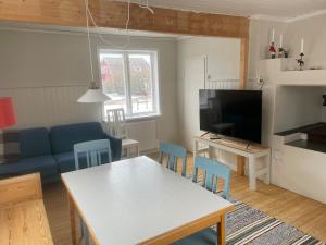 a living room with a table and a blue couch at Lissmogården in Leksand