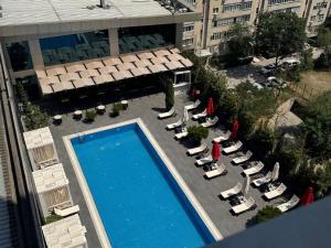 an overhead view of a swimming pool with lounge chairs and a hotel at Bishkek Park Apartments in Bishkek +3 photos