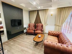a living room with a couch and chairs and a television at Three Trees Hotel Islamabad in Islamabad +32 photos