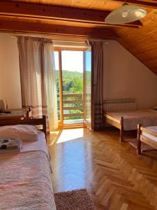 a bedroom with two beds and a large window at House Draga Plitvice near the lakes and bus stop in Plitvička Jezera