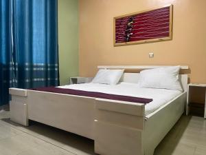 a bed in a bedroom with a blue curtain at Mona Rusizi in Cyangugu