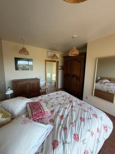a bedroom with a large bed and a mirror at Casa Poupa in Lagoa