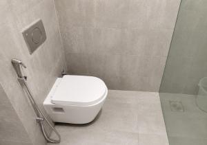 a bathroom with a white toilet and a shower at Hotel Somani Wakad in Méribel Village