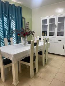 a dining room with a white table and chairs at Mona Rusizi in Cyangugu