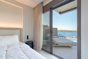 a bedroom with a bed and a balcony with the ocean at Villa Incanto in Nydri