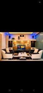 a living room with two couches and a tv at Kabirbnb in Chittaurgarh