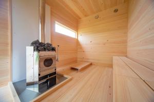 a sauna with a stove in a wooden room at TUZUMI Wakayama Susami in Esumi