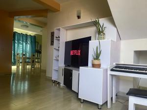 a living room with a piano and a television at Mona Rusizi in Cyangugu