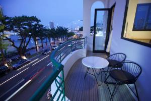 a balcony with a white table and chairs and a street at Emlyhome Hanriver in Danang +15 photos