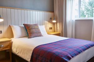 1 dormitorio con 1 cama con una manta colorida en Pen and Parchment by Greene King Inns, en Stratford-upon-Avon