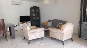 a living room with two chairs and a couch at Anavyssos Serenity Villa in Anavyssos