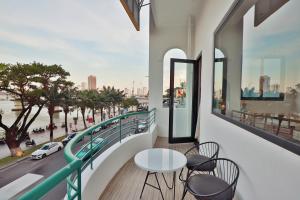 a balcony with tables and chairs and a view of a city at Emlyhome Hanriver in Danang