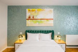 a bedroom with a white bed with a green headboard at In Grand Hotel & SPA in Bucharest +60 photos