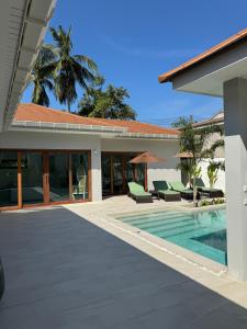 a villa with a swimming pool and a house at Villa Palm Sip Sam in Ko Phangan