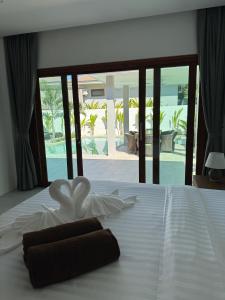 a white bed with a brown towel on top of it at Villa Palm Sip Sam in Ko Phangan +13 photos