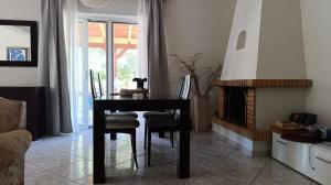 a dining room with a table and a fireplace at Anavyssos Serenity Villa in Anavyssos