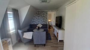 a living room with a blue couch and a tv at Berghaga in Köping