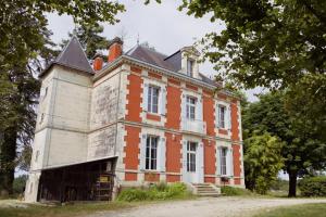 an old red brick building with a turret at Chateauneuf in Sadirac