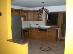 a kitchen with wooden cabinets and a stainless steel refrigerator at Spacious holiday home in Przesieka with sauna in Przesieka
