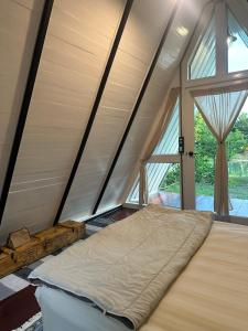 a bed in a room with a large window at 385 Homestay & Lake camp in Ban Khai Nao (1)