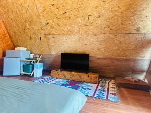 a room with a bed and a tv on a wall at 385 Homestay & Lake camp in Ban Khai Nao (1)