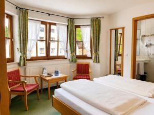 a bedroom with two beds and a table and chairs at Hotel Schatten in Garmisch-Partenkirchen