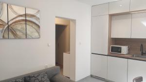 a kitchen with white cabinets and a microwave at Apartman Iva in Kaštela