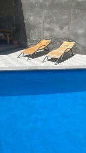 two wooden chairs sitting next to a swimming pool at fam rest in Garni