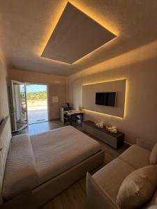 a bedroom with a bed and a tv on the wall at Agriresort Murciano in Otranto