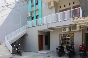 two motorcycles parked next to a building with a staircase at RedDoorz near UGM 3 in Yogyakarta