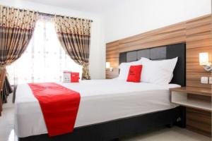 a bedroom with a large white bed with red pillows at RedDoorz near UGM 3 in Yogyakarta