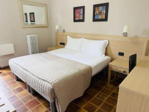 a hotel room with a bed and a mirror at HOTEL Monte Cimone in Caldonazzo +2 photos