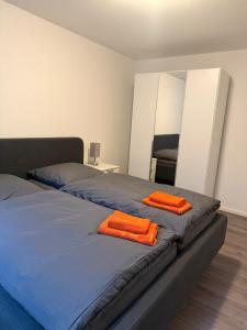 two orange towels on a bed in a bedroom at Dünenhaus Souterrain Strandallee 3 in Timmendorfer Strand