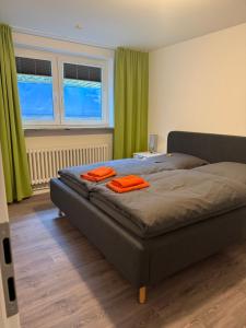 a bedroom with a bed with orange towels on it at Dünenhaus Souterrain Strandallee 3 in Timmendorfer Strand