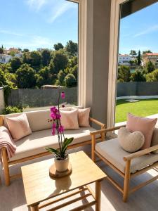 a living room with couches and a large window at Chillout House with heated pool 29 C Sea & Mountain view in Santa Susanna