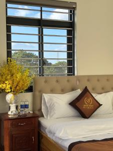 a bed in a room with a large window at Hotel QUỐC TUẤN in Ban Ay Dlă (2)
