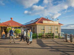 a group of people walking in front of a building at 2 bedroom 2 level Apartment - Hydra Holiday Unit 6 in Merimbula