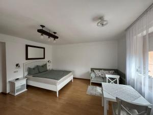 a bedroom with a bed and a couch and a table at GaLiBa Vendégház in Jenő