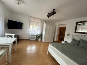 a bedroom with a bed and a table and a television at GaLiBa Vendégház in Jenő