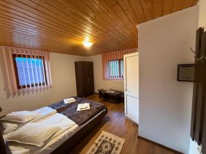 a bedroom with a bed and a wooden ceiling at Gold Fayen House Cheile Turului in Tureni