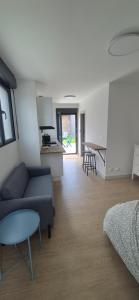 a living room with a couch and a table and a kitchen at Studio between city and countryside in Lompret
