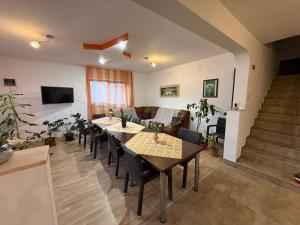 a living room with tables and chairs and a couch at Gold Fayen House Cheile Turului in Tureni