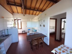 a kitchen and dining room with a table and a room at Podere S.Giulia - casale S.Giulia in Riotorto