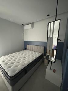 a bedroom with a white bed and a mirror at Angelica Suites Keramoti Area in Keramoti