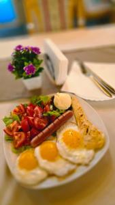 a plate of breakfast food with eggs sausage and vegetables at Vila Bucan in Rožaje