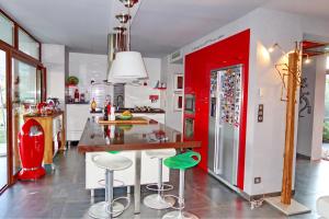 a kitchen with a red refrigerator and a counter with stools at Villa Mare Monti in Lumio
