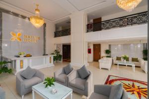 a lobby of a hotel with couches and tables at Nature Hotel and Suite in Da Lat