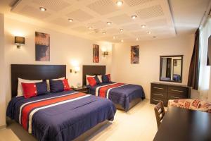 a hotel room with two beds and a table at Hotel Grand Elizabeth in Durango +12 photos