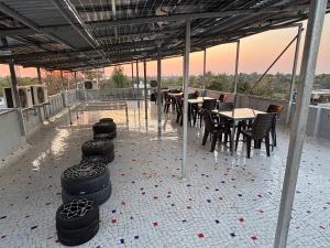 a patio with tables and chairs and tires on the floor at Unity homestay in Garudeshwar